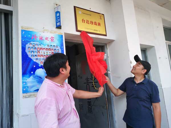 新華愛心教育基金會潘瑜副秘書長（右）為寧德市民族中學(xué)臺達(dá)珍珠班揭牌